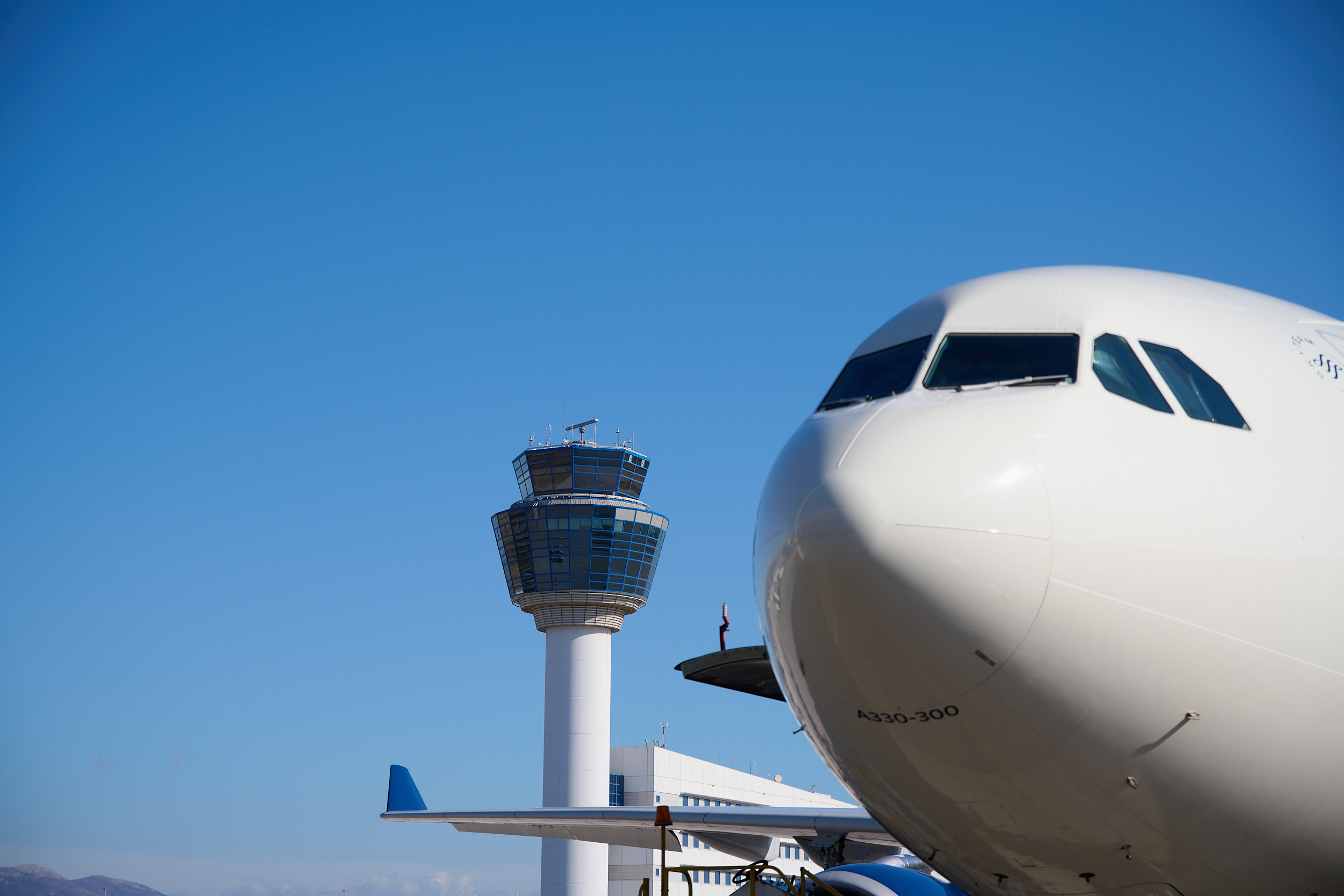 photo of an airplane in front of the control tower