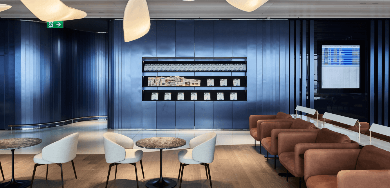 Business lounge with armchairs and magazines and newspapers on the wall