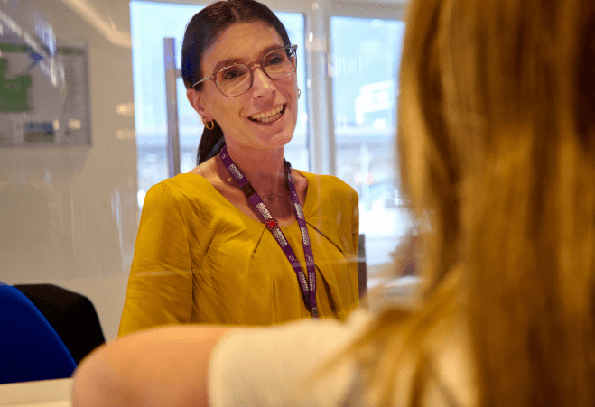 Airport employee providing information to a passenger at Athens International Airport